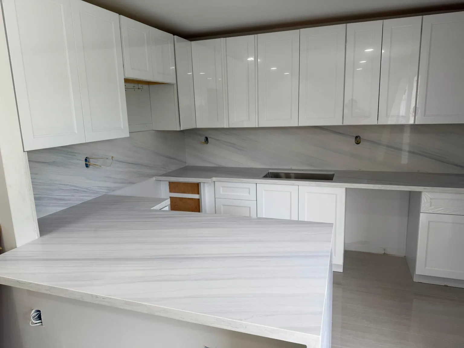 White shaker kitchen cabinetry with stone countertop
