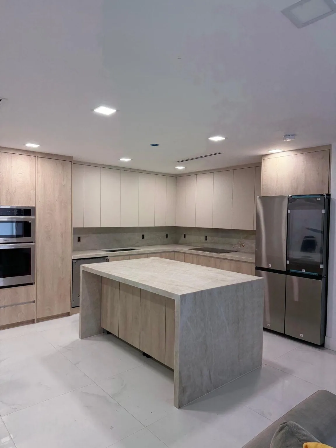 Modern kitchen with light wood cabinetry and a stone-topped center island