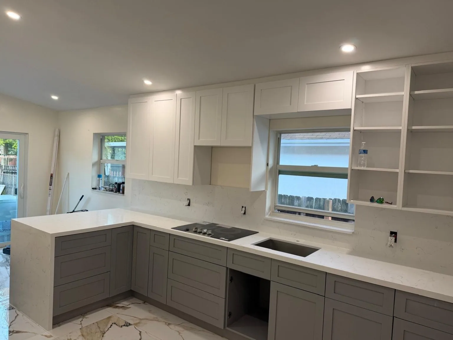 Kitchen with white and gray shaker cabinetry and white stone countertops