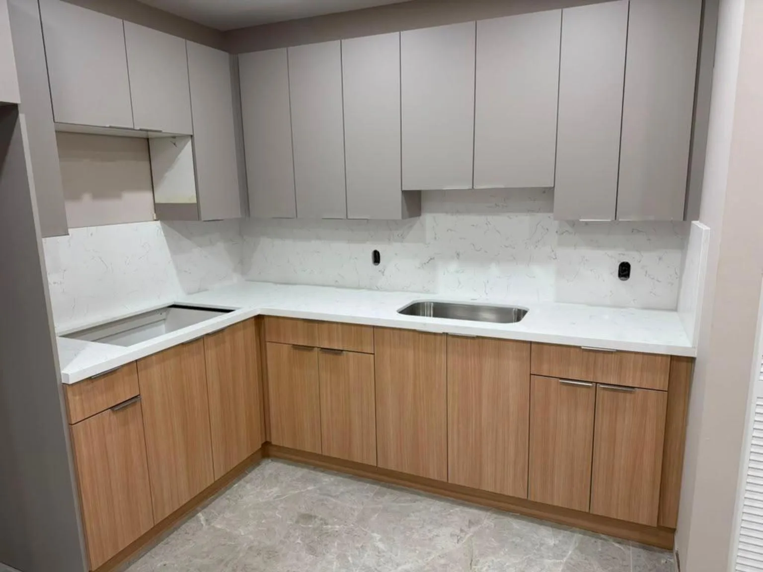 Kitchen with white upper cabinets, wood lower cabinets and white stone countertops