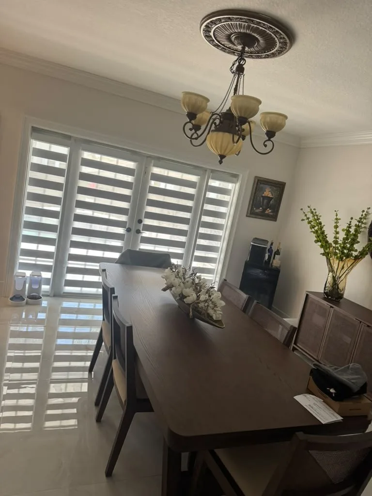 Zebra dual shades mounted on french doors in a dining area